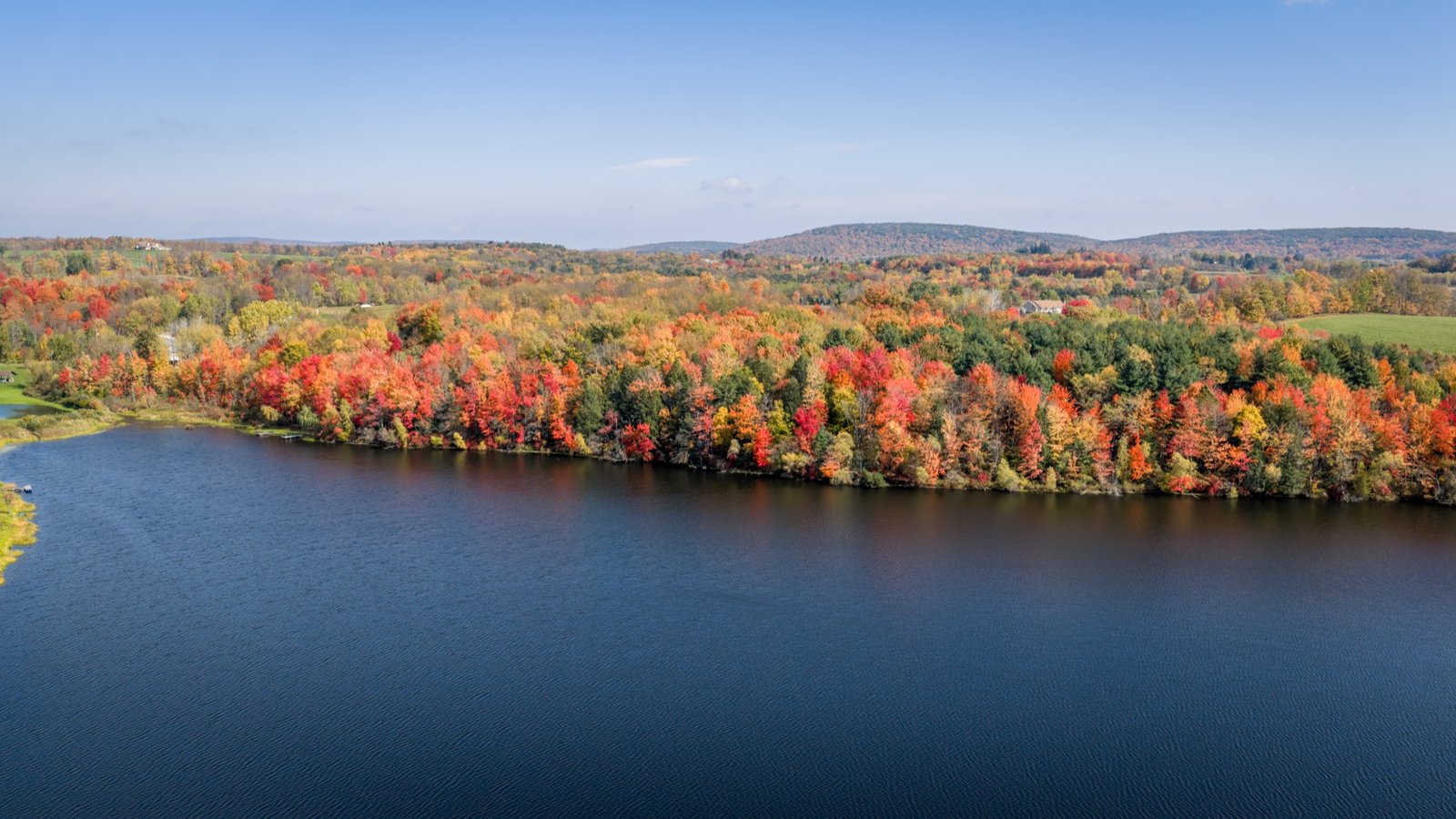 Lake edged with bright red and orange autumn trees