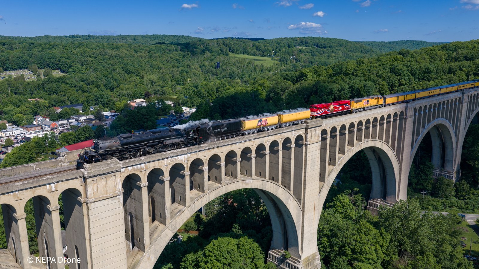 Steam train crossing the Tunkhannock Viaduct above the trees