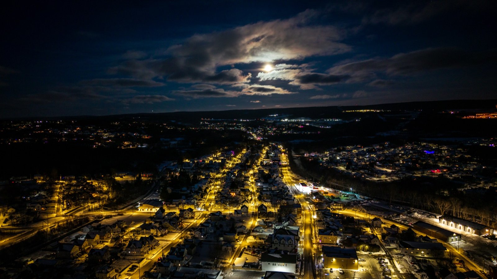 Town lights glowing under a moonlit sky